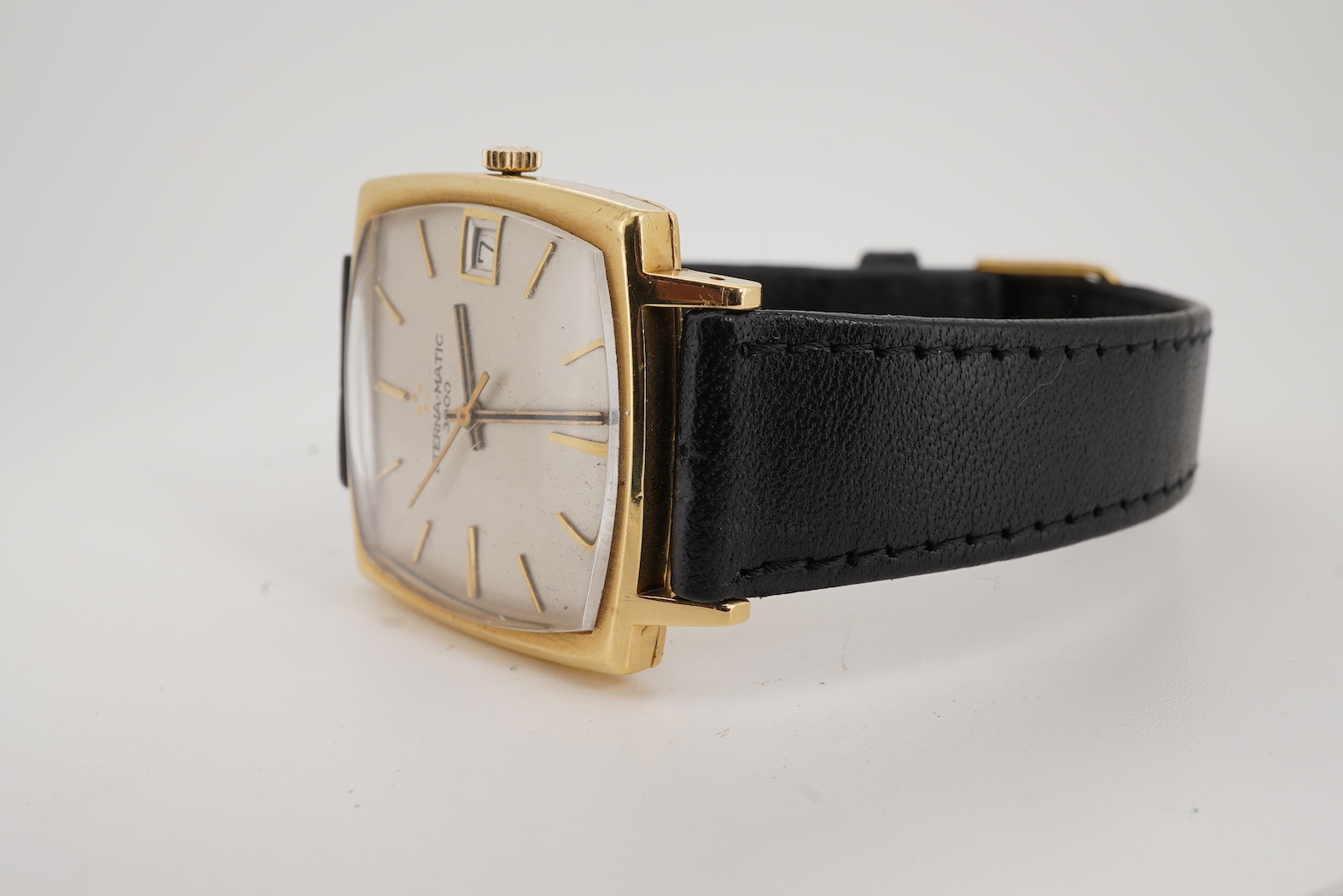 A gentleman's 18ct gold Eterna-Matic 3000 wrist watch, with baton hour marker, centre seconds hand and calendar aperture at 3 o’clock, on an associated black leather strap